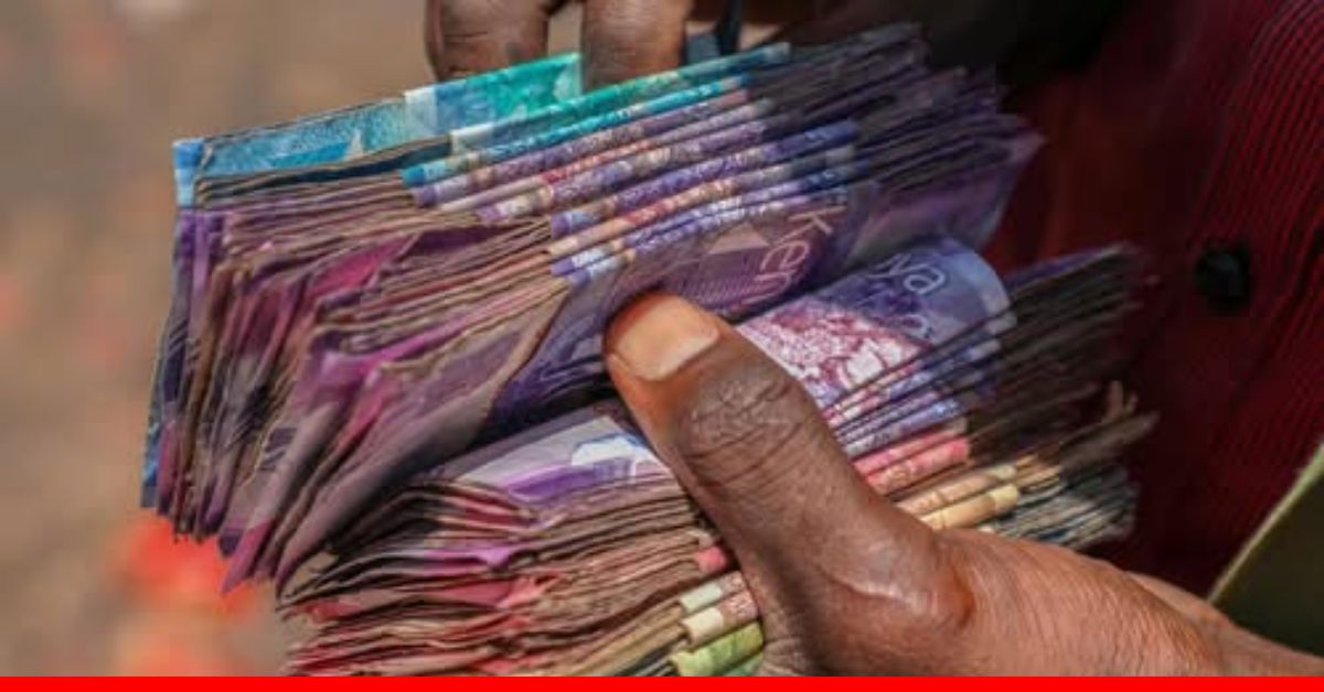A MAN HANDLING BUNDLES OF KENYAN MONEY IN HIS HAND